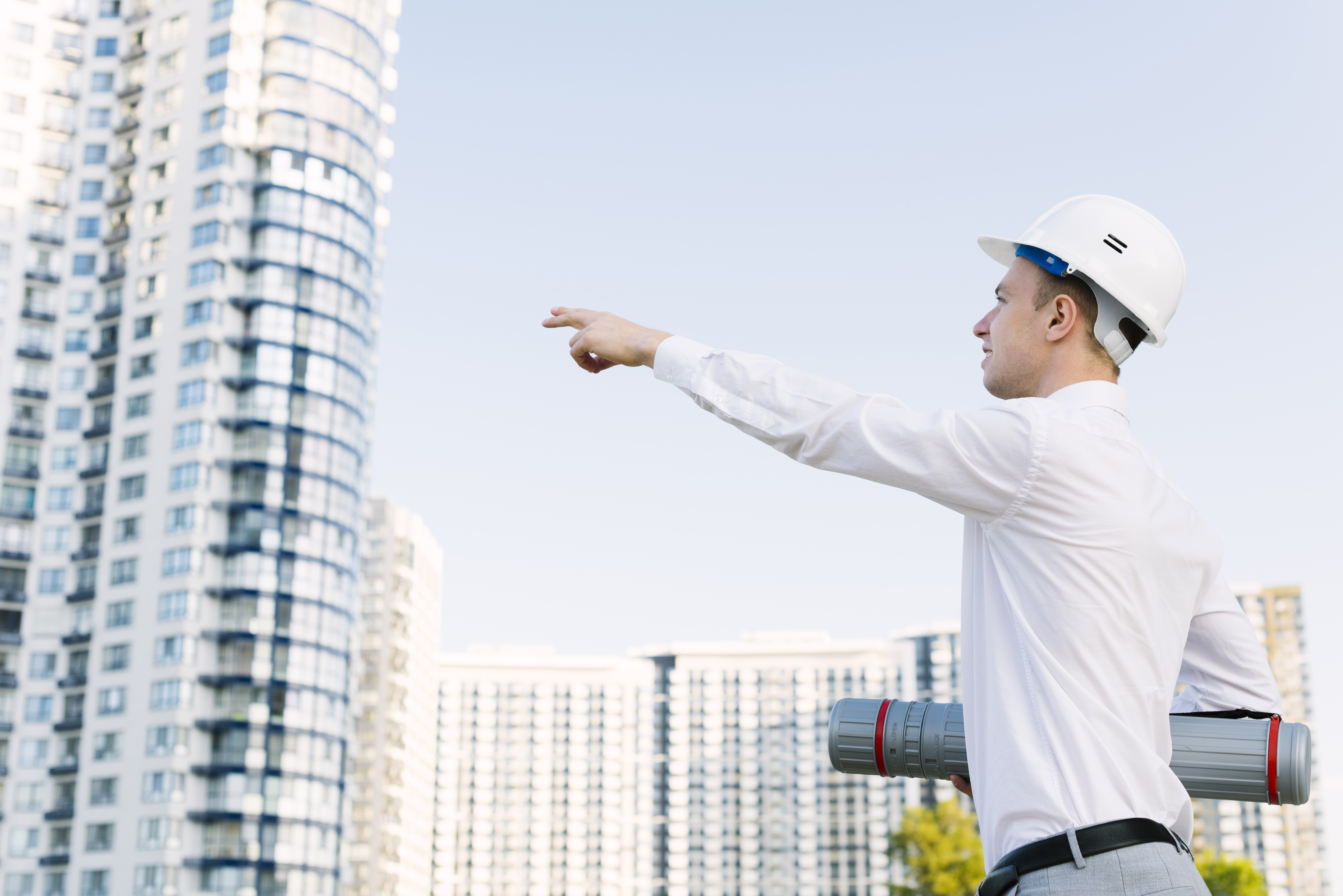 side-view-man-with-helmet-pointing-building